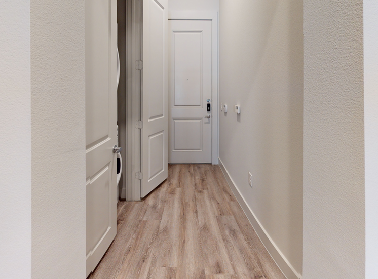 Entry way with wood style flooring and closet with washer and dryer