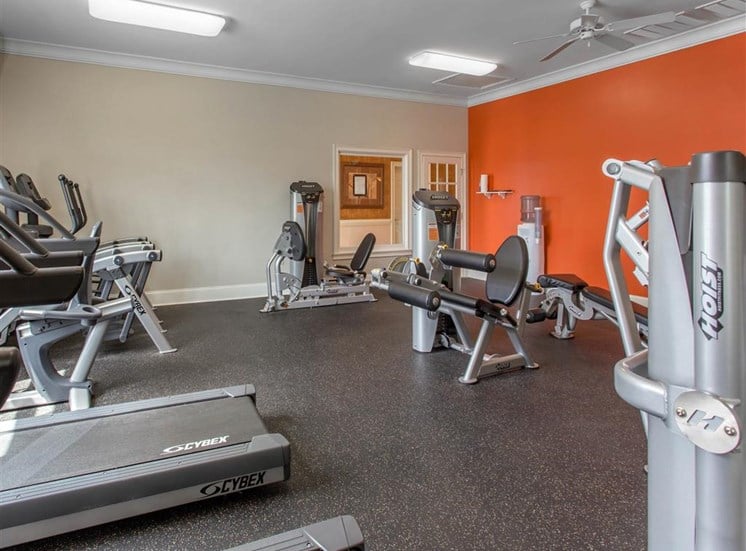 Fitness Center with Exercise Equipment with Orange and Mirror Accent Wall