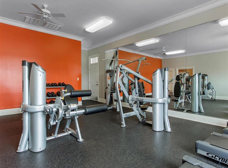 Fitness Center with Exercise Equipment with Orange and Mirror Accent Wall