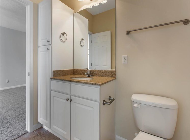 Bathroom with Tan Counters White Cabinets and Linen Closet