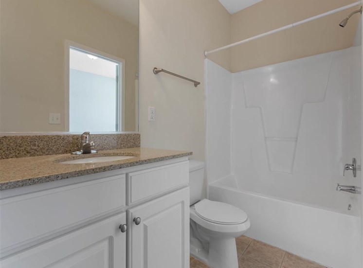 Bathroom with Bathtub and Shower Tan Counters White Cabinets and Linen Closet Door