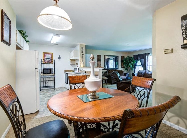 Open Model Floor Plan with Dining Room Table in DIning Room with Kitchen and Ling Room in the Background