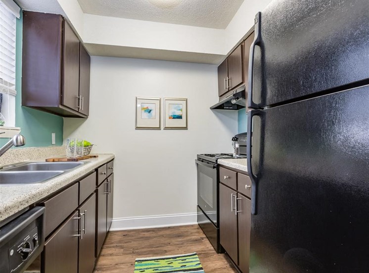 Fully Equipped Kitchen with Brown Cabinets and Black Appliances