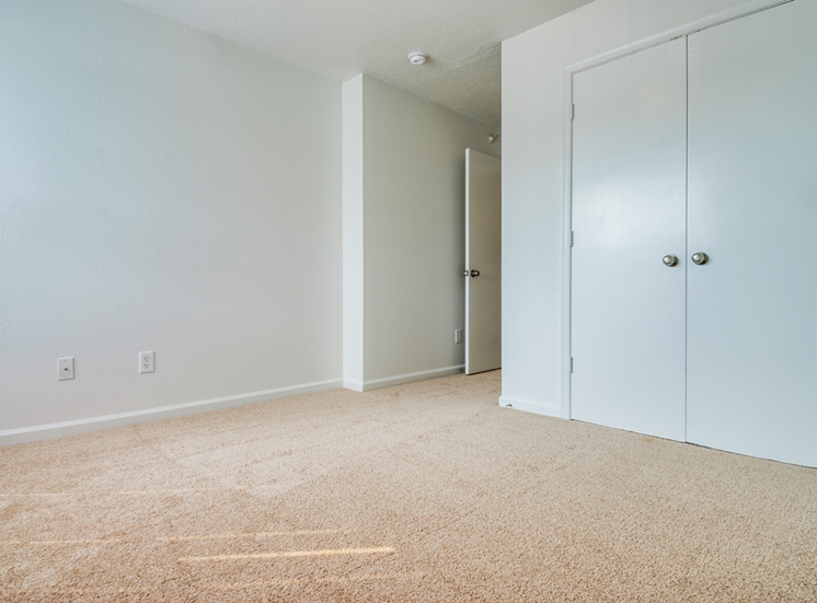 The bedroom has wall to wall carpet and double doors leading to closet.