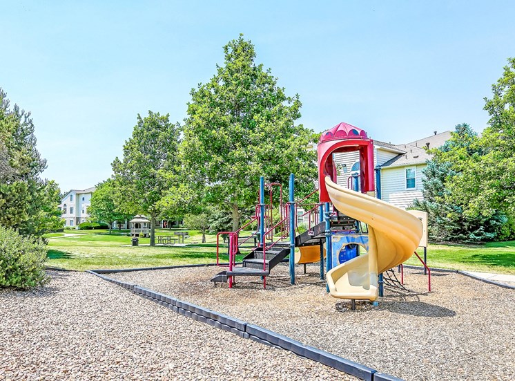 Playground on Mulch in Grassy Courtyard with Building Exterior in the Background