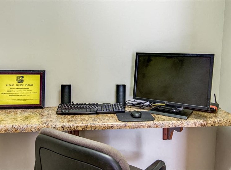 Business Center with Computer Next to Keyboard and Speakers Next to Yellow Sign