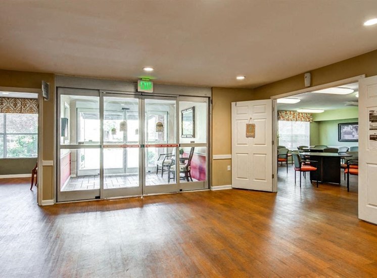 Spacious Entryway Into Community Center with Large Doors Next to Lounge Area with Tables and Chairs