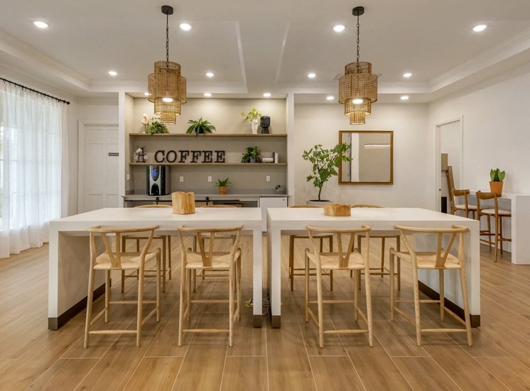 Community room table with eight chairs, table decor, kitchen area with coffee, fridge and shelves