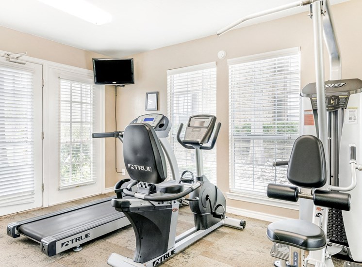 Fitness center with cardio machines, mounted tv on the left corner of room