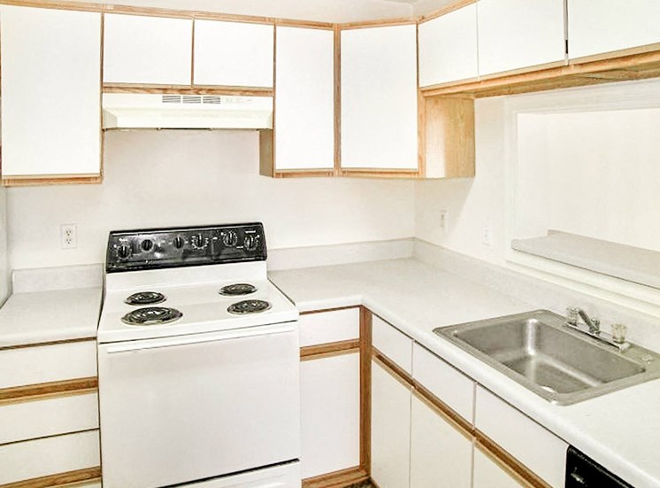 White cabinets and appliances with hardwood style flooring