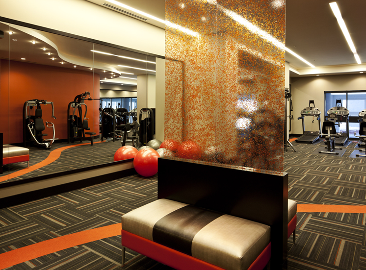 Fitness center with cardio equipment with large window and mirrored walls