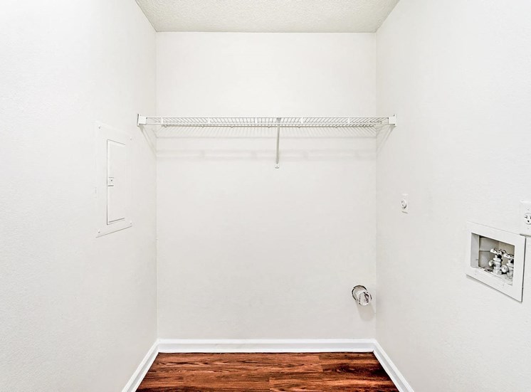 Laundry room with white walls and hardwood style flooring