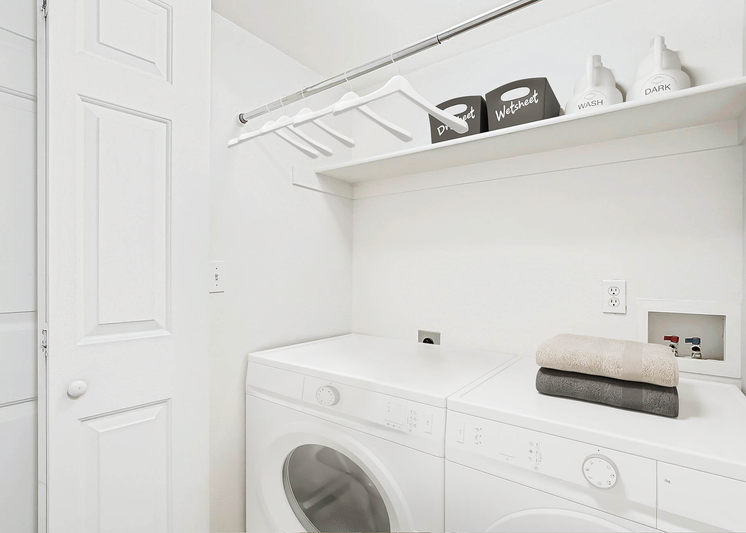 Laundry machines with a shelf and metal bar overhead