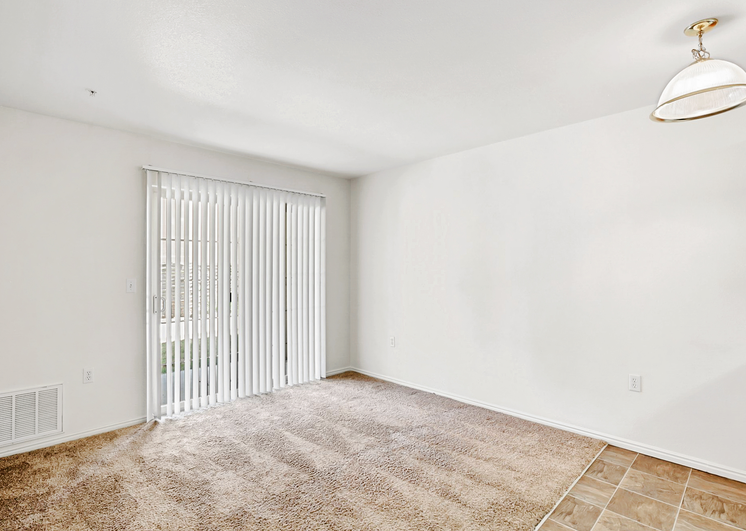 Carpeted living room facing sliding windowed door