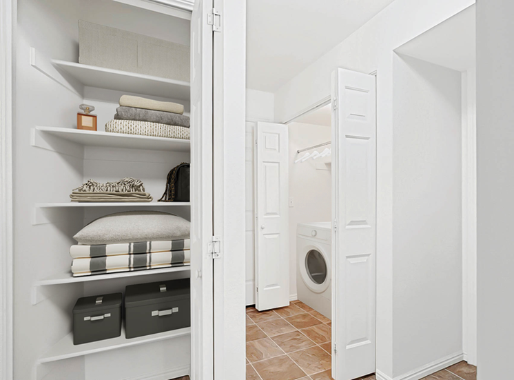 View of hallway with laundry machines and shelved linen closet