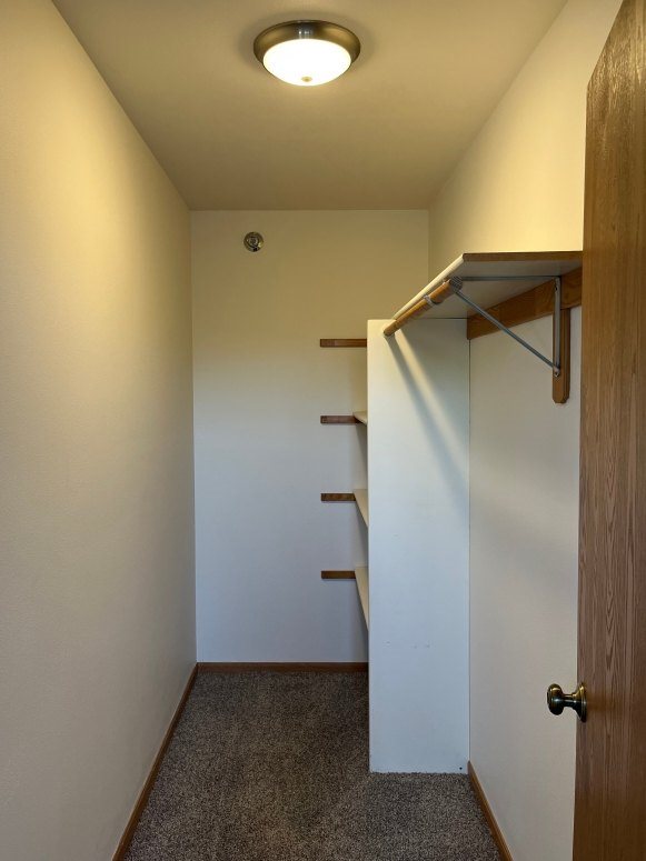 A hallway with a light on the ceiling and a door on the right.