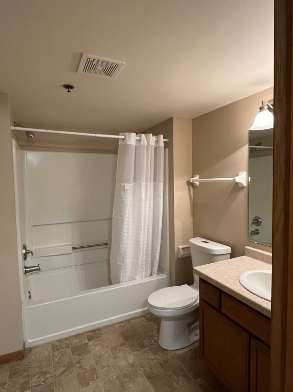A white toilet sits next to a sink in a bathroom.