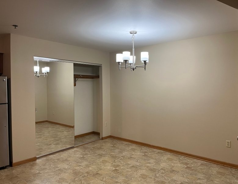 A room with a chandelier, wall sconces, and a mirror.