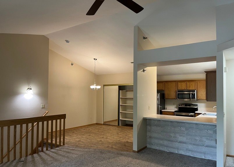 A modern kitchen with a ceiling fan and a countertop.