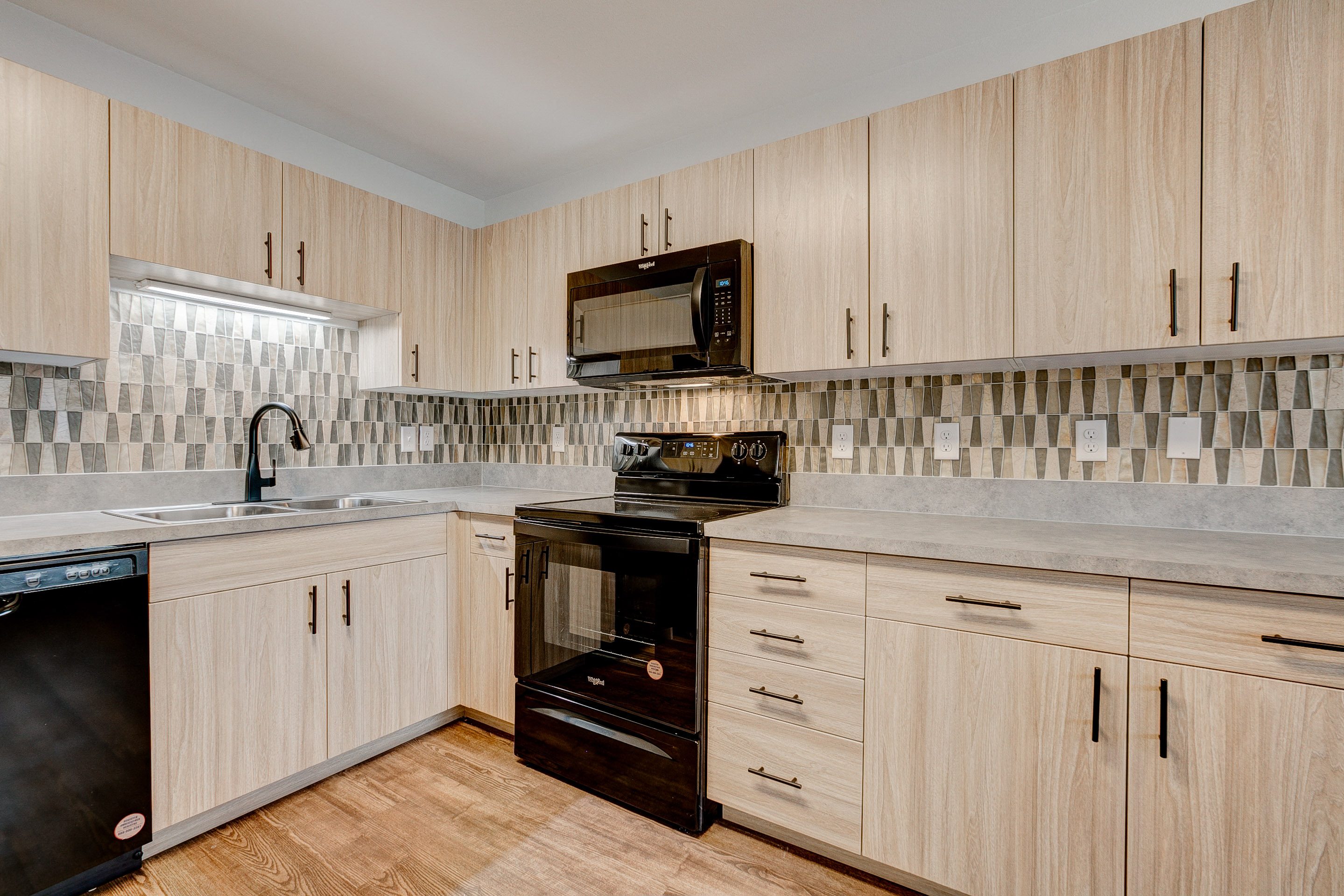 A kitchen with wooden cabinets and a black oven.