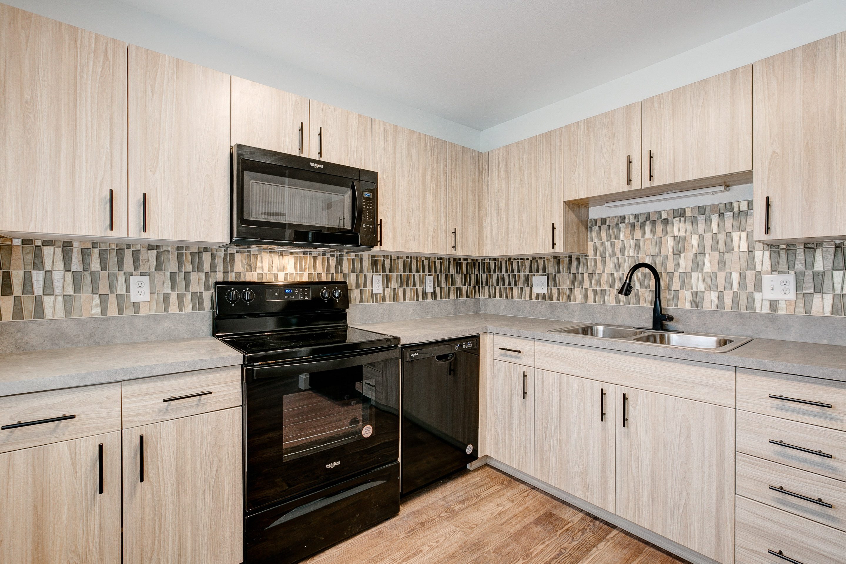 A kitchen with wooden cabinets and a black stove top oven.