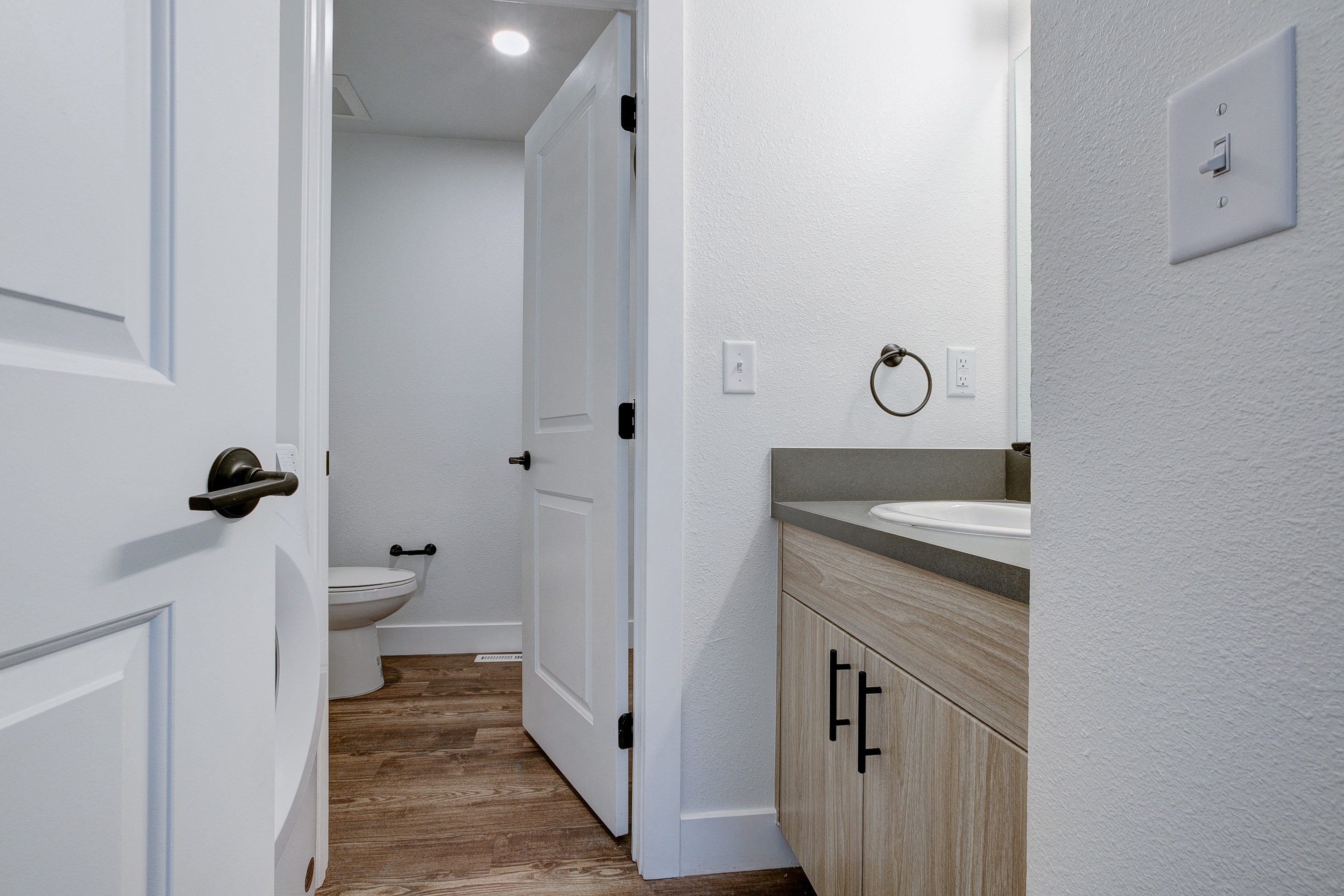 A bathroom with a toilet, sink, and cabinet.