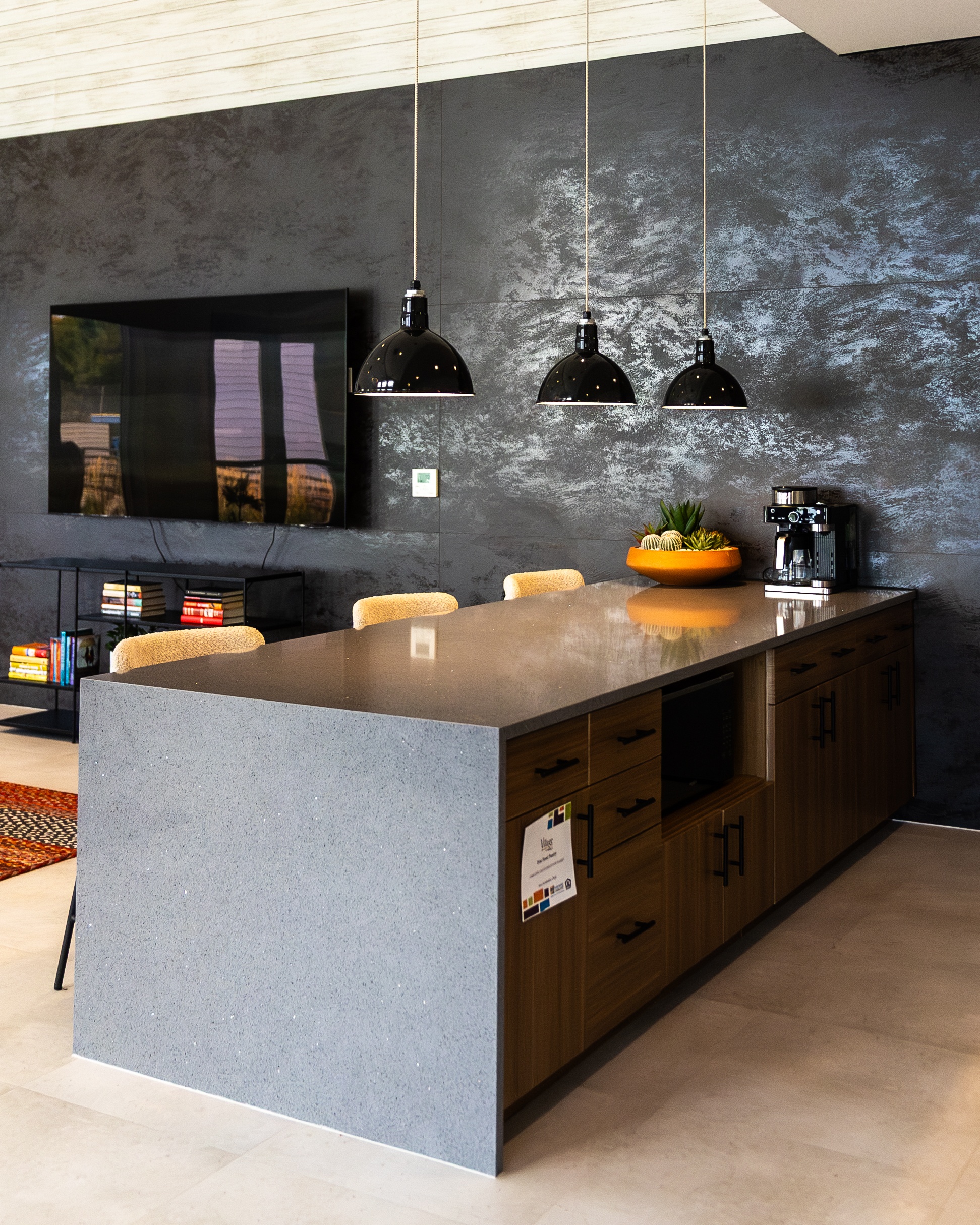 A modern kitchen with a grey counter and a grey wall.