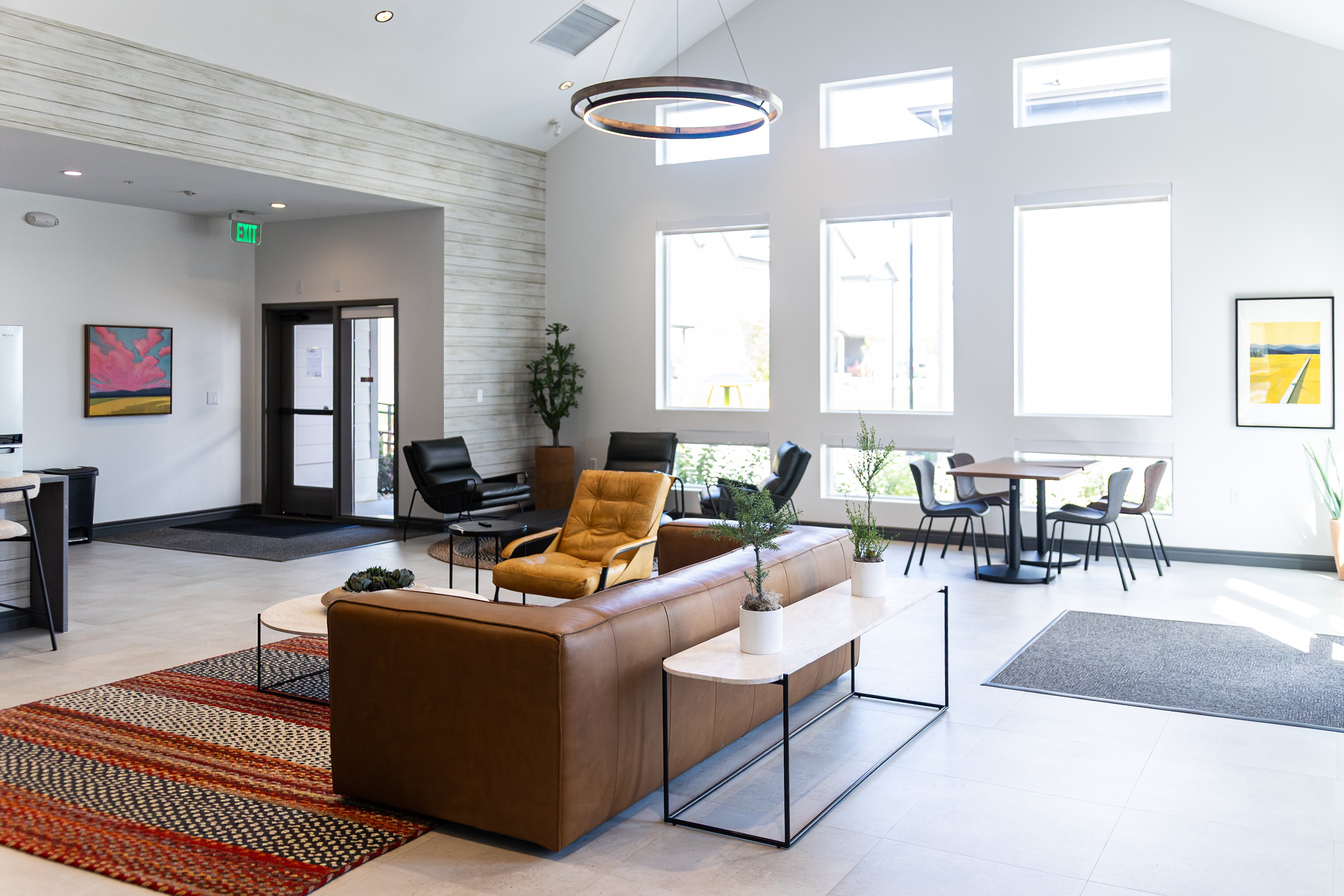 A modern living room with a brown sofa and a glass coffee table.