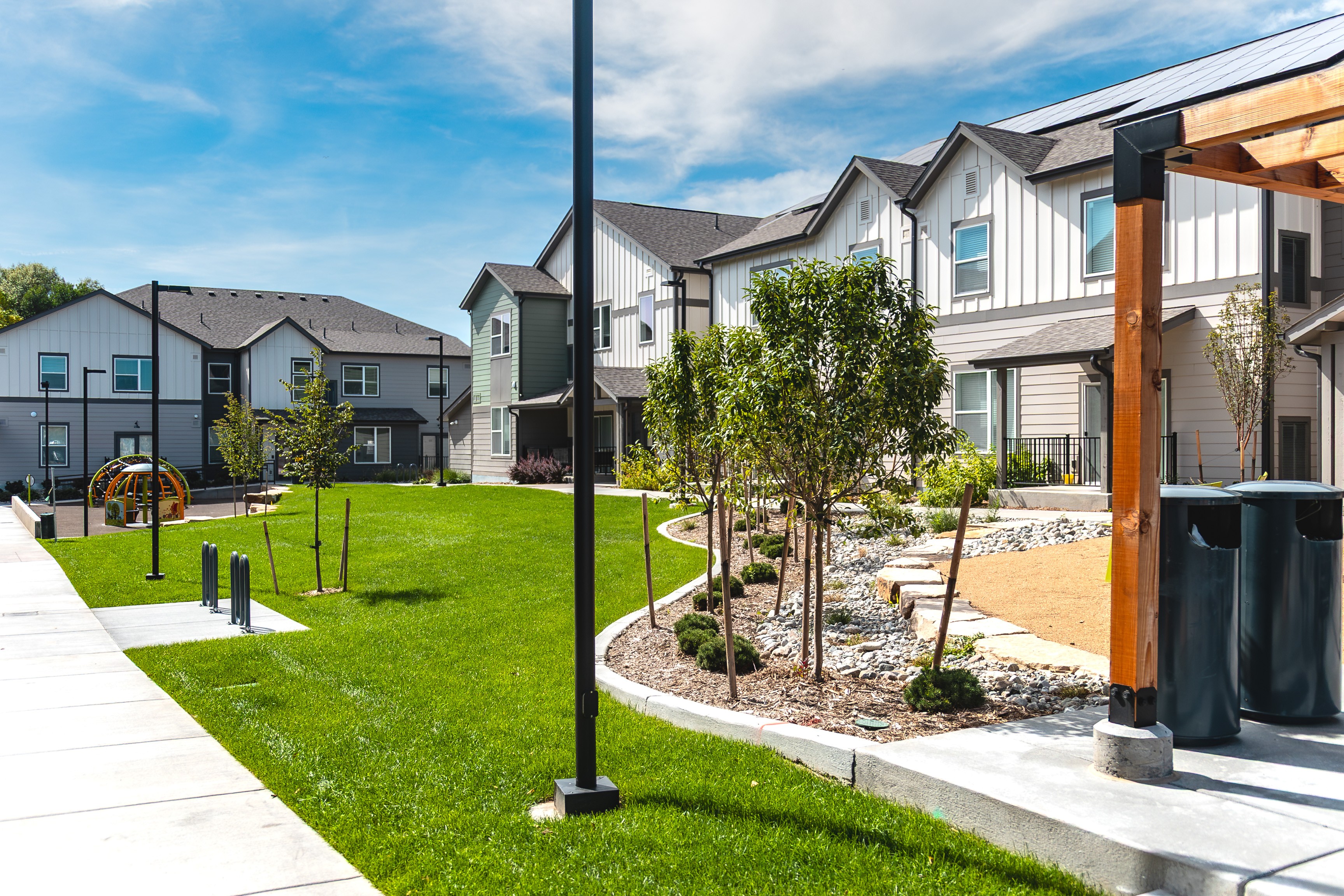 A row of houses with a green lawn in front.