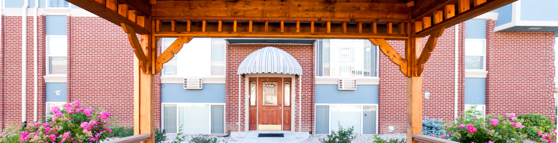 A red brick building with a wooden entrance canopy.