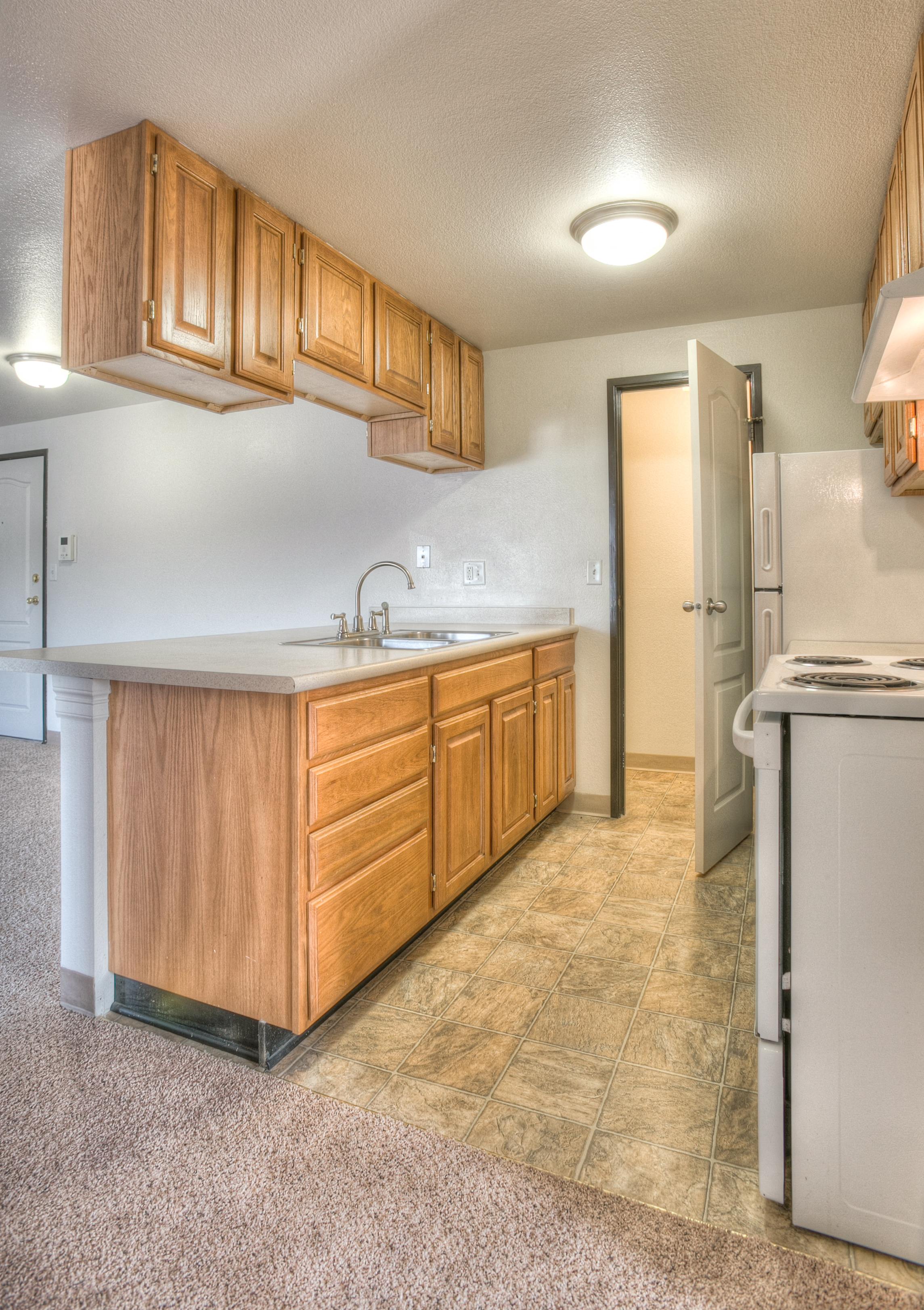 A kitchen with wooden cabinets and a white dishwasher.