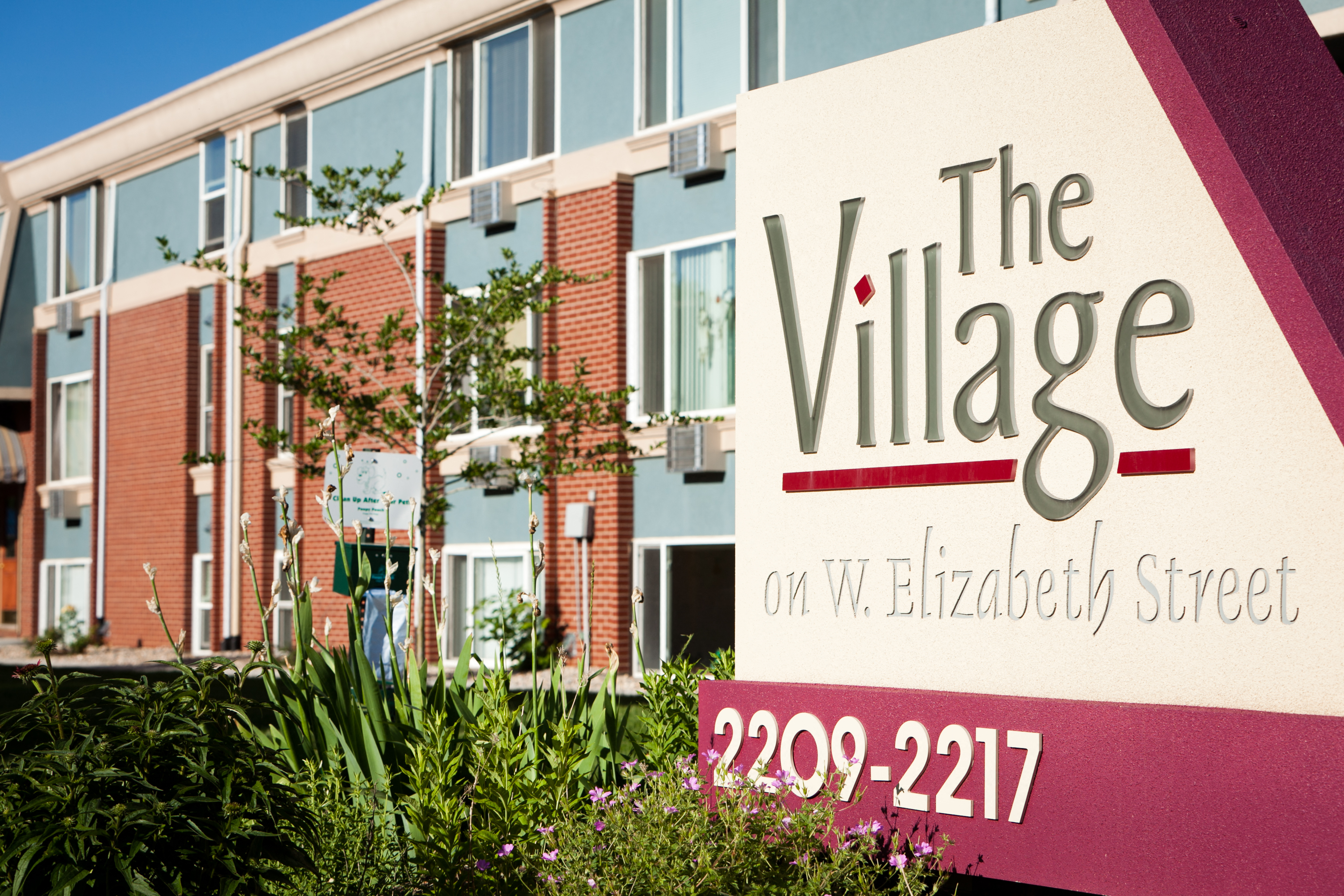 A sign for The Village on W. Elizabeth Street with a phone number.