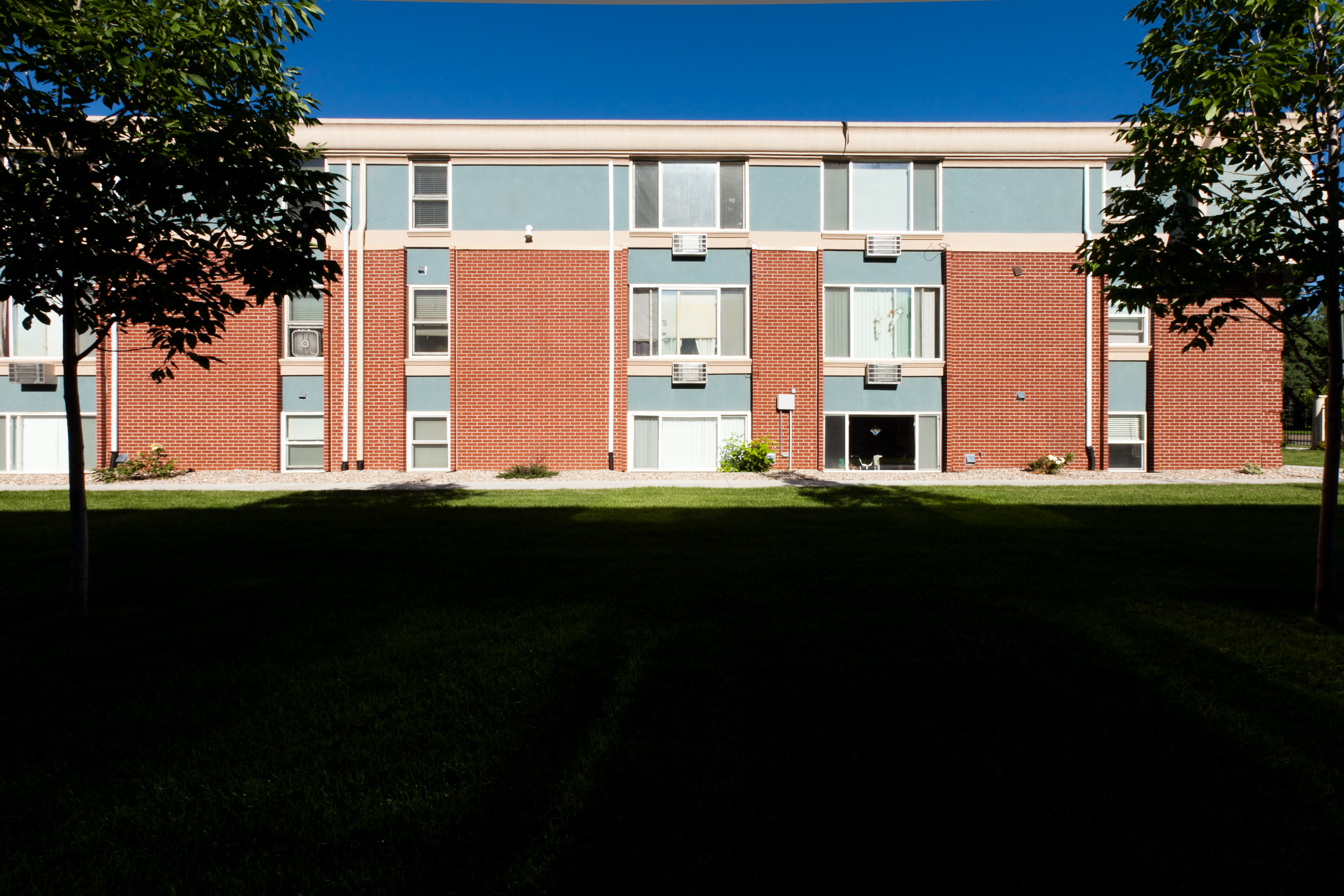 A red brick building with a black door and windows.