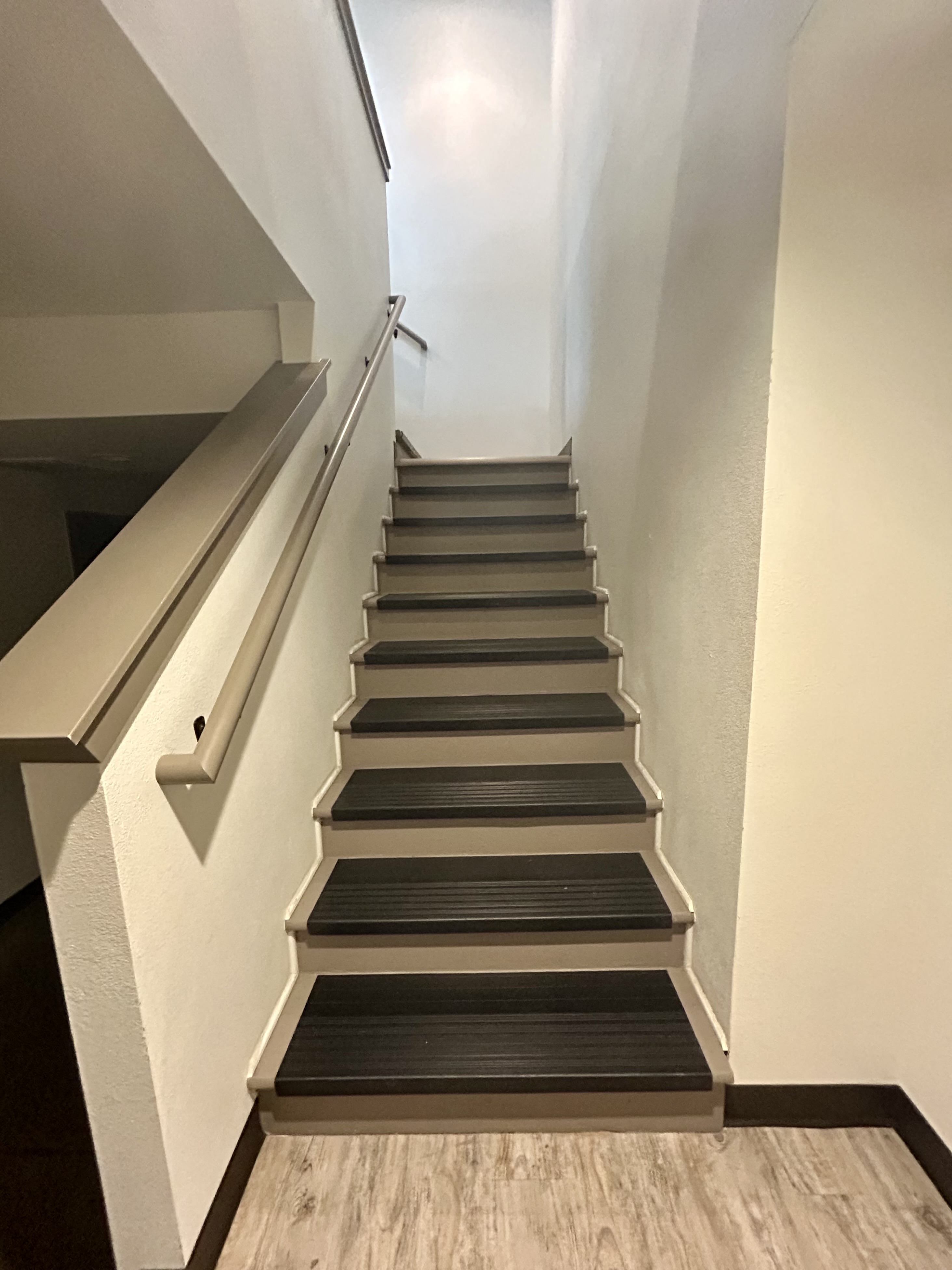A set of stairs with a wooden floor and metal handrails.