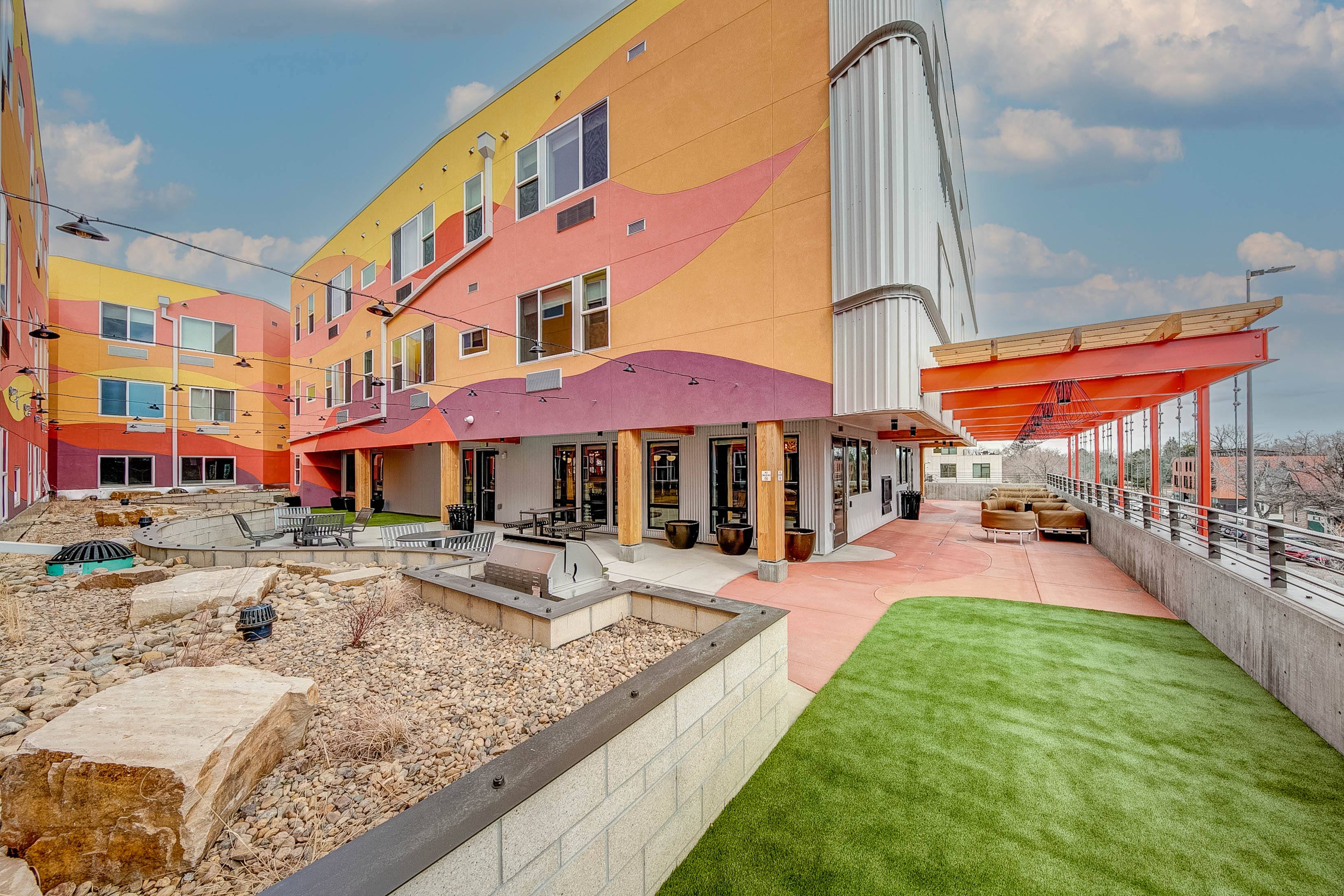 Third floor terrace with gas grill, tables, and artificial turf