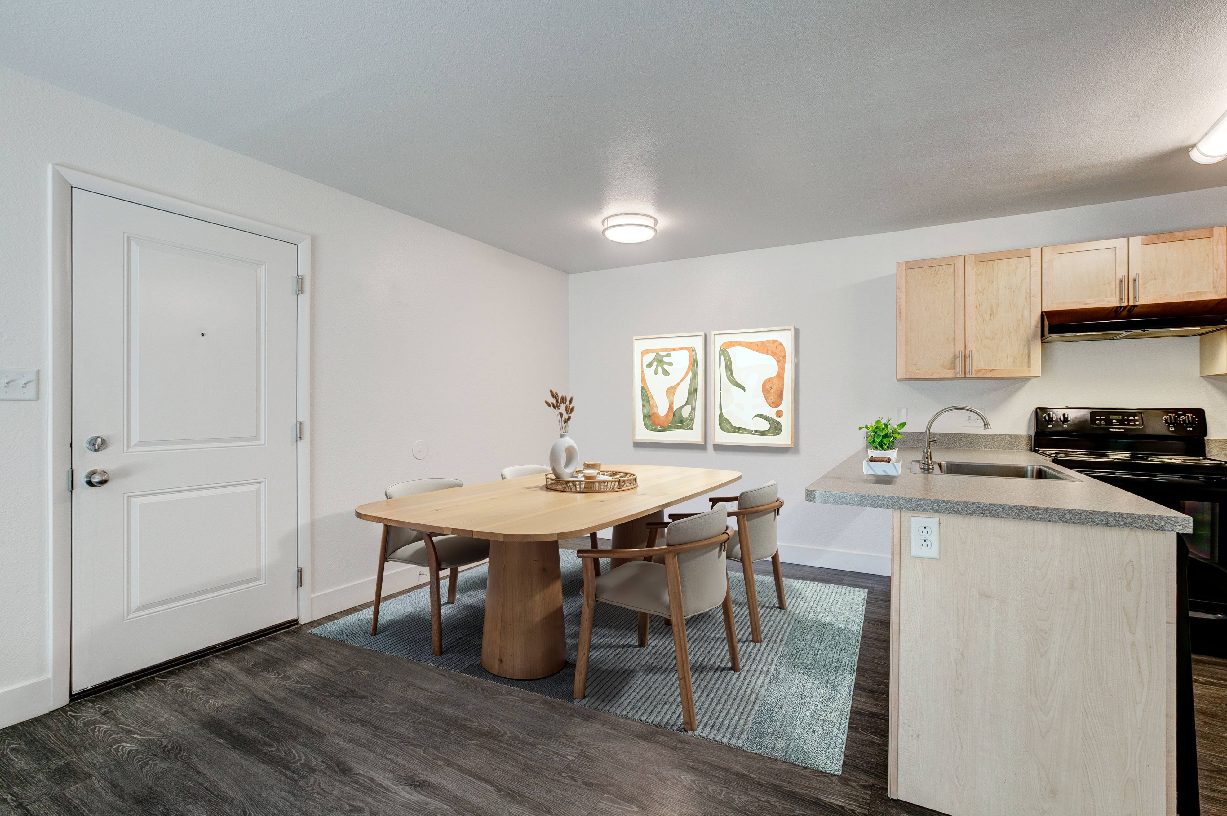 A kitchen with a table and chairs in the middle of the room.,A kitchen with a table and chairs in the middle of the room.
