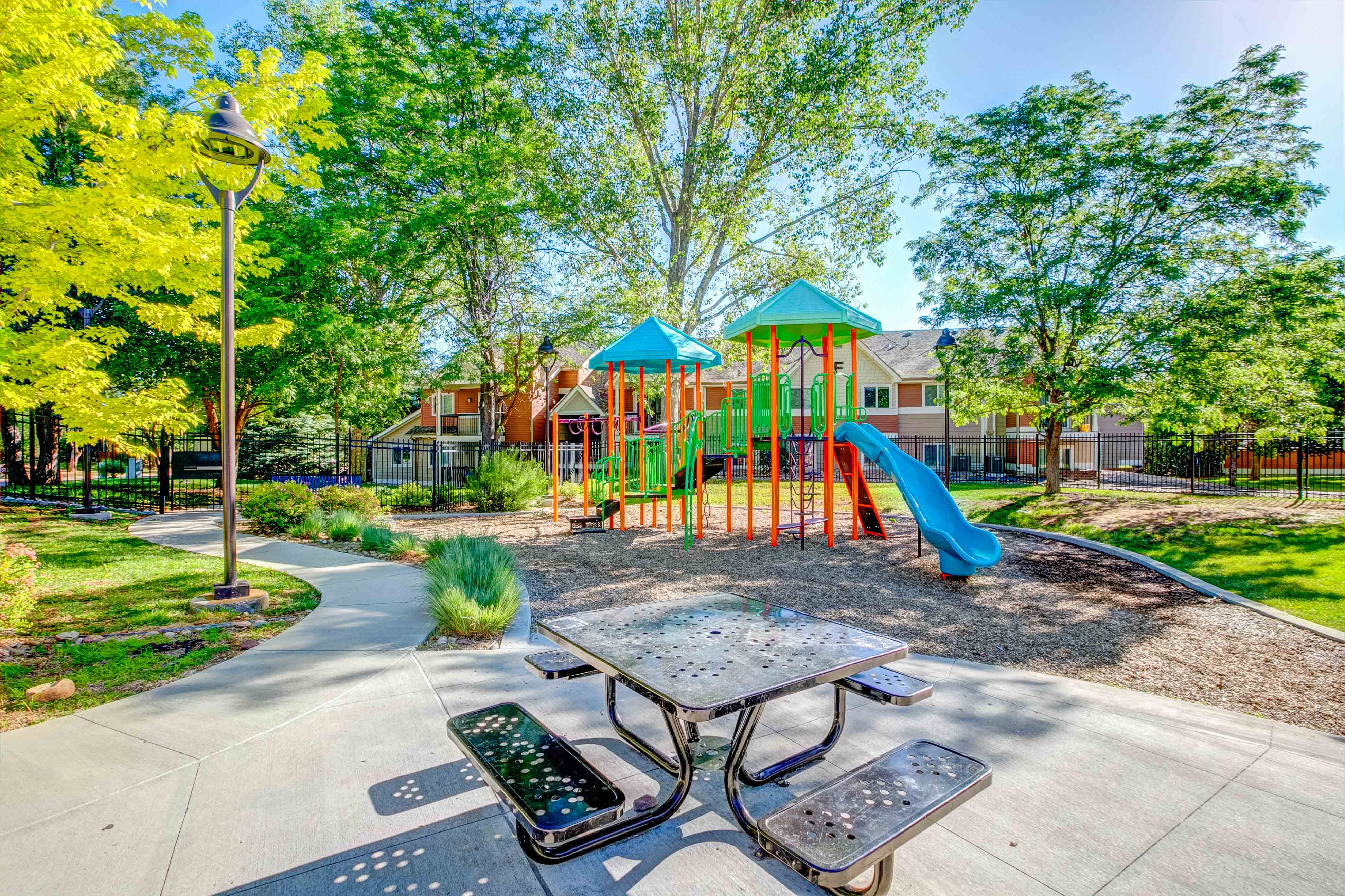 A playground with a slide, swings, and a table with a phone on it.