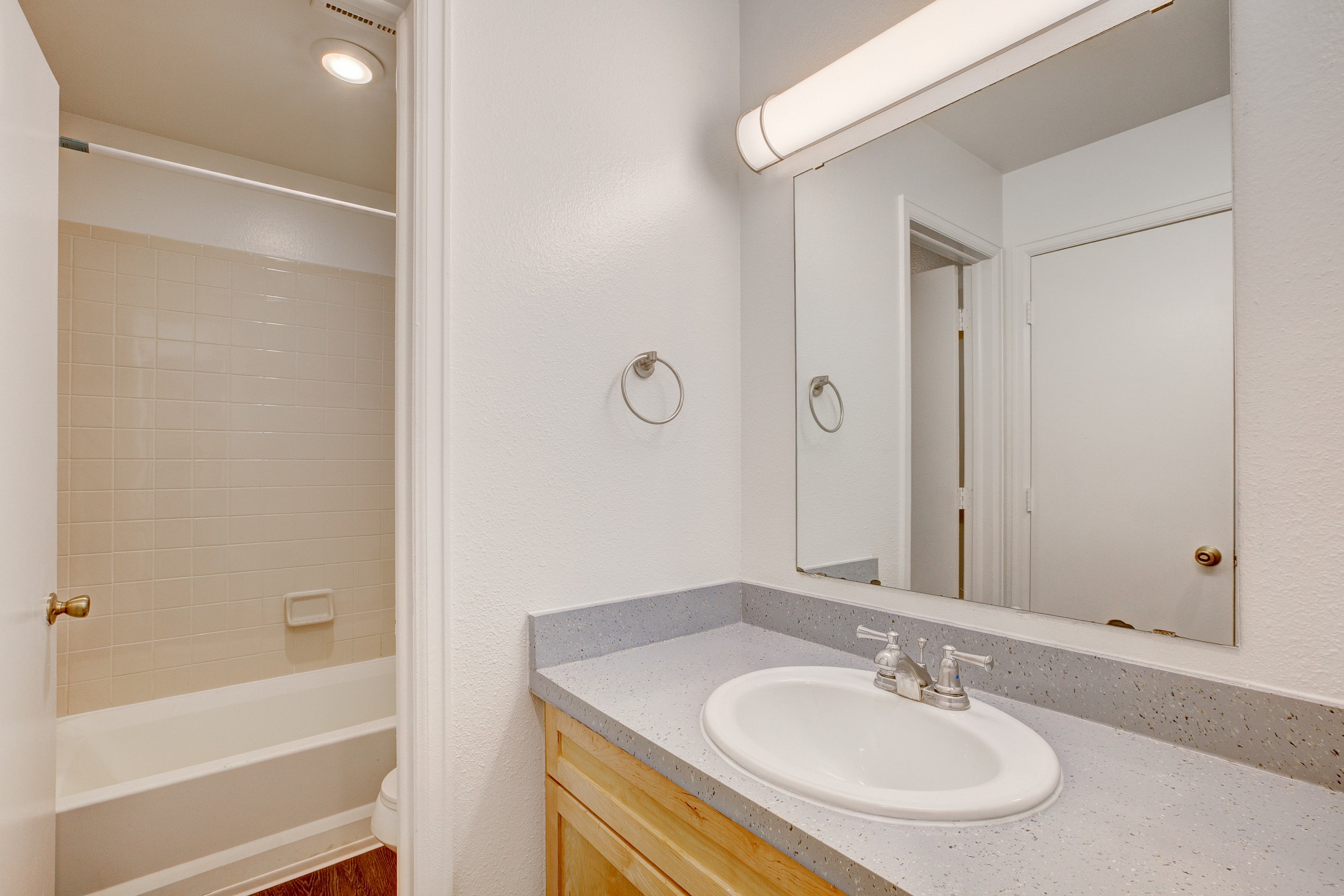A bathroom with a white sink and a mirror.