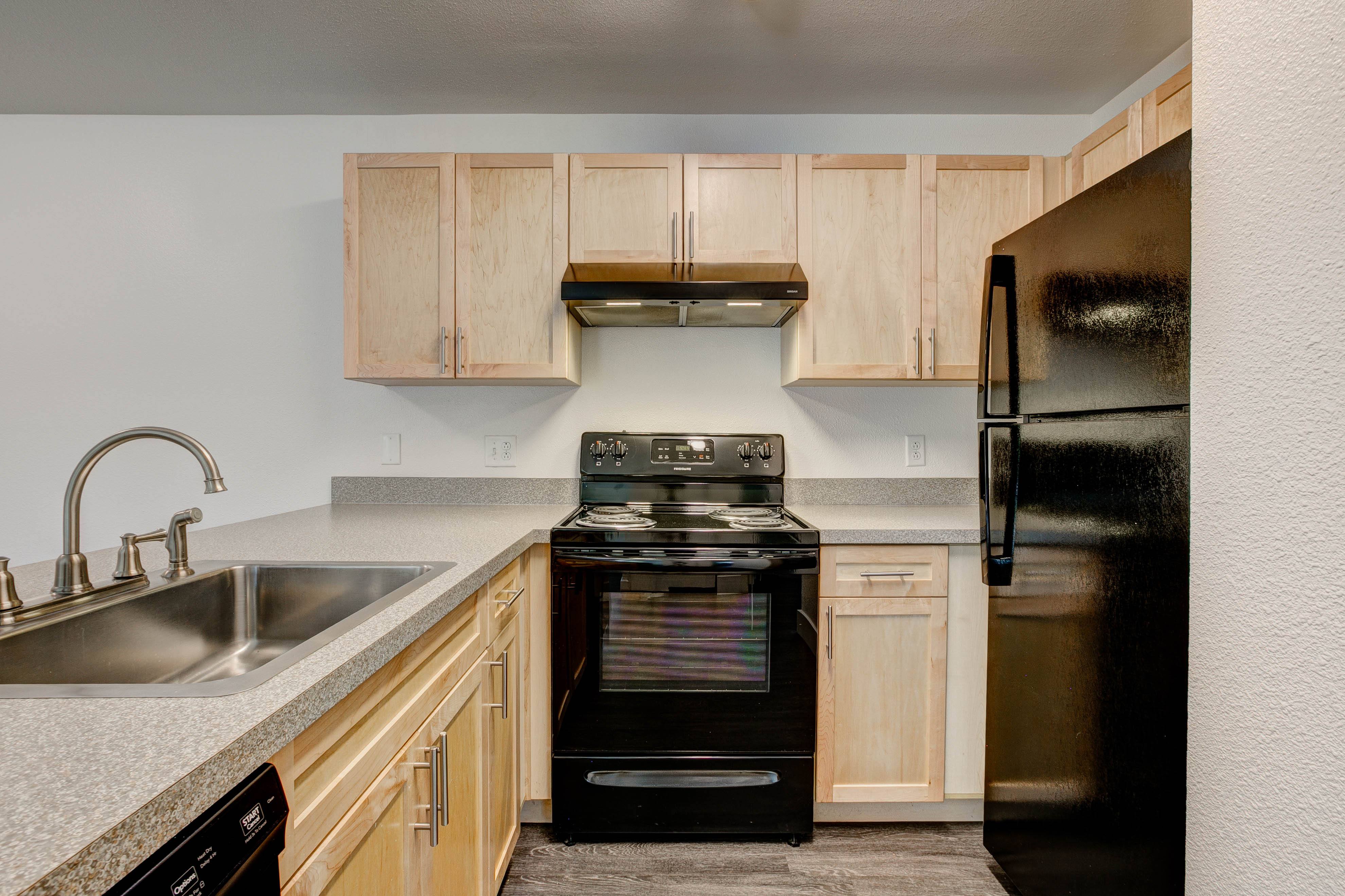 A kitchen with a black refrigerator, stove, and dishwasher.,A kitchen with a black refrigerator, stove, and dishwasher.