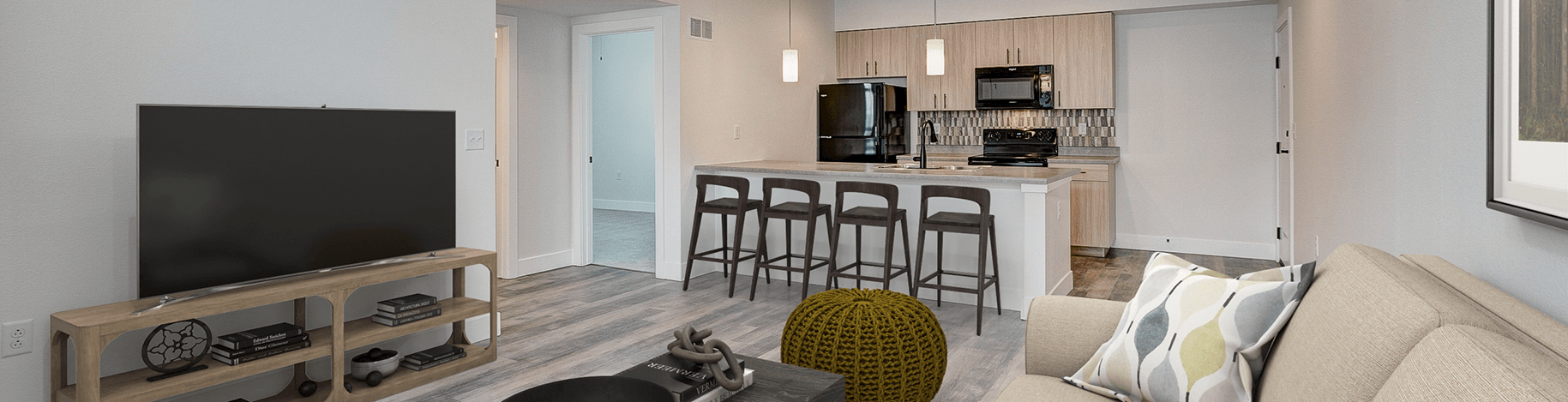 A living room with a couch, a television, and a bar area.