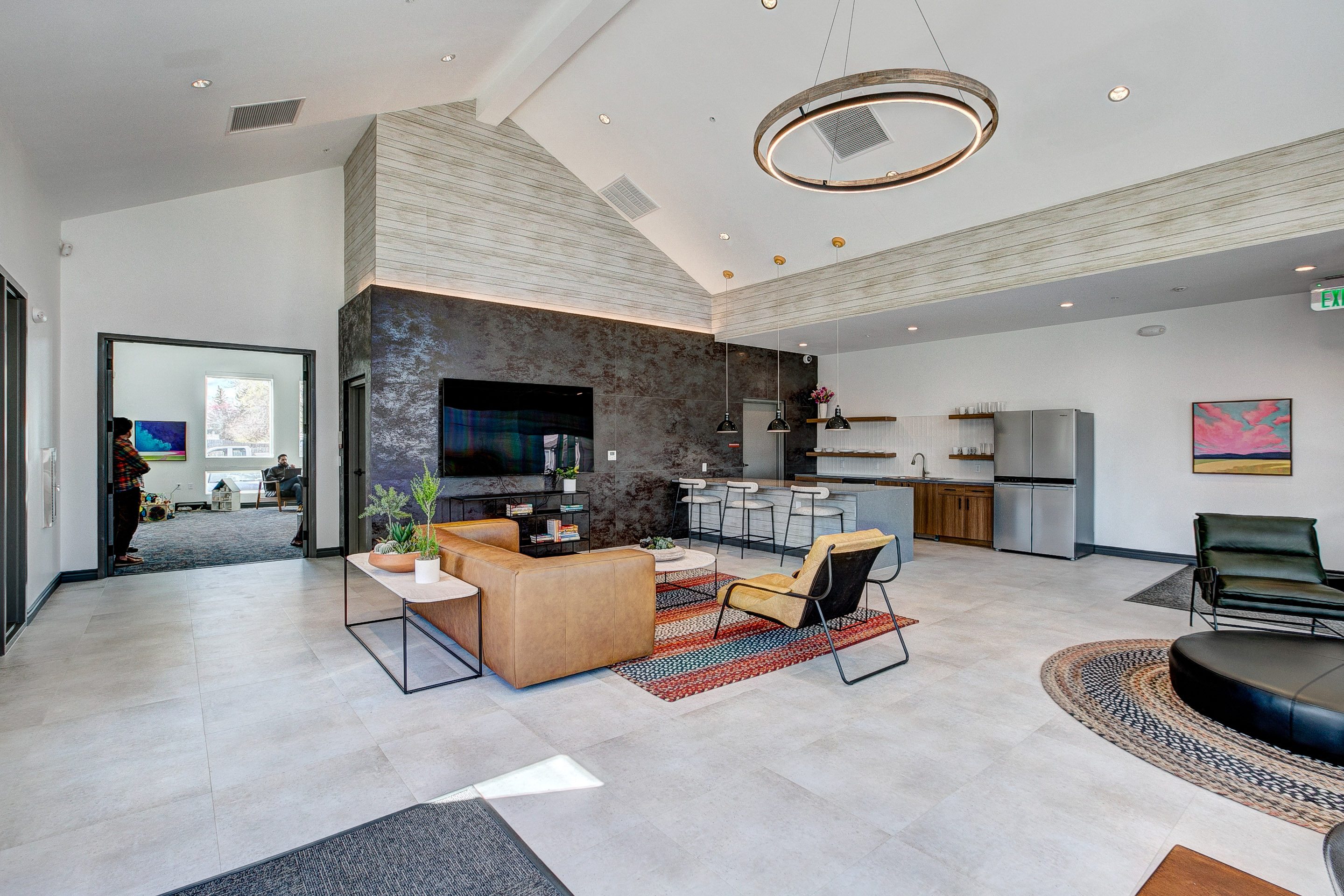 A modern living room with a stone fireplace and a large rug.