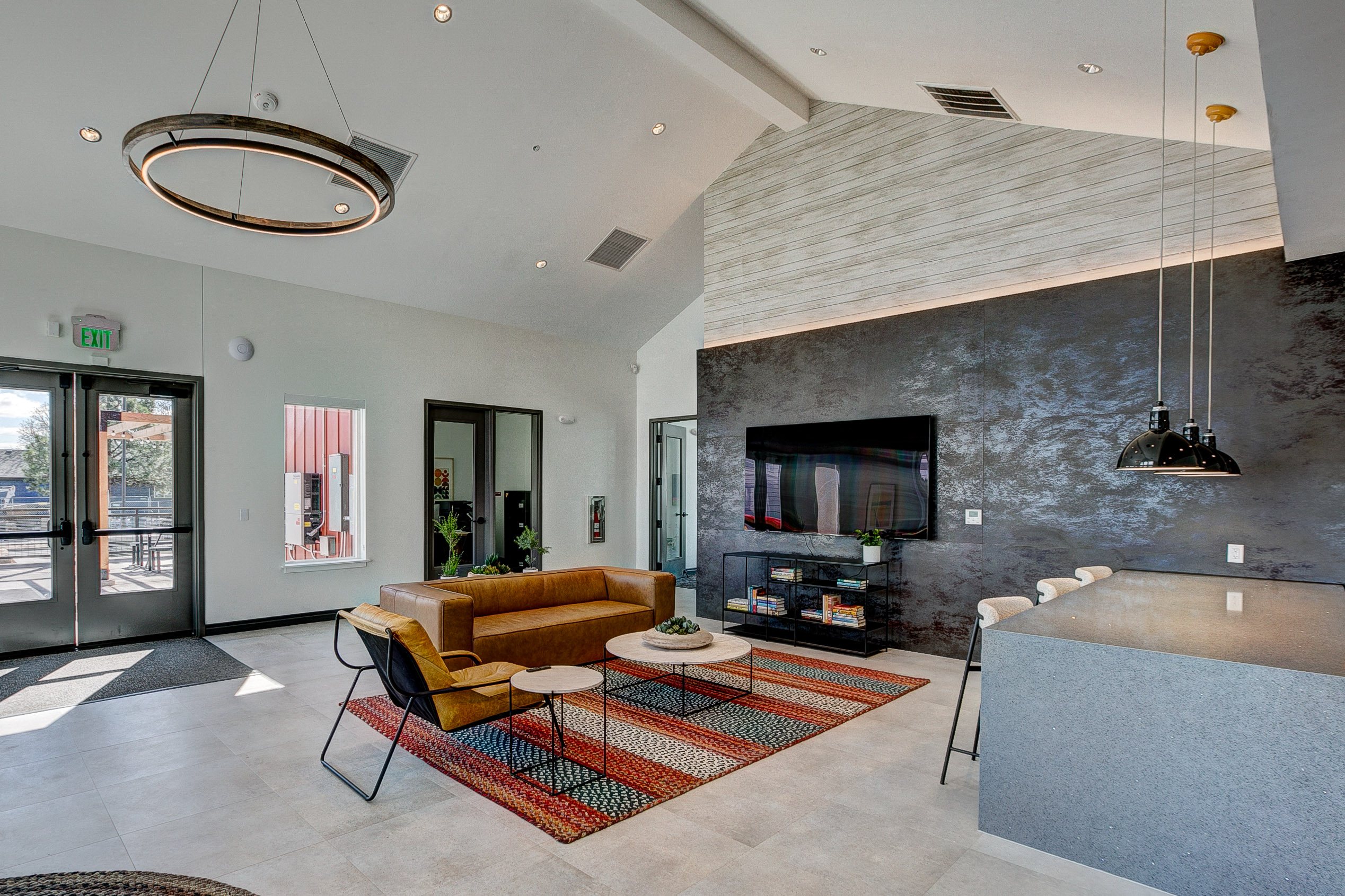 A modern living room with a brown sofa and a grey counter.