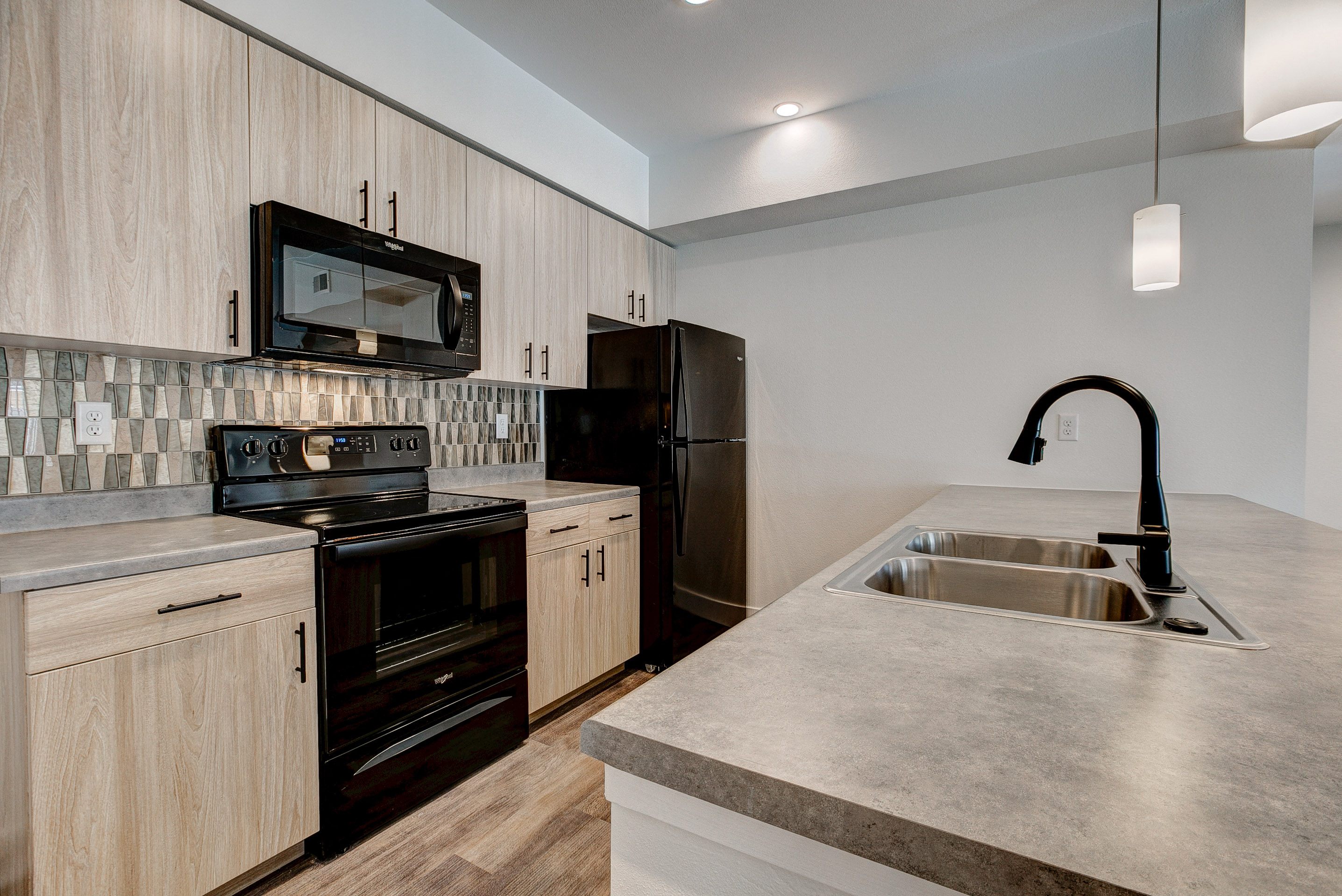 A modern kitchen with a stove, oven, microwave, and refrigerator.