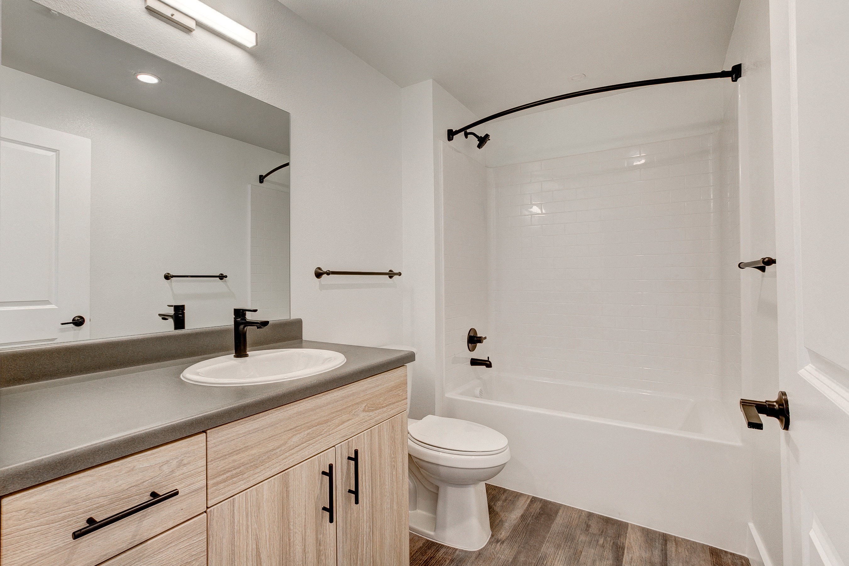 A bathroom with a white toilet and a white bathtub.