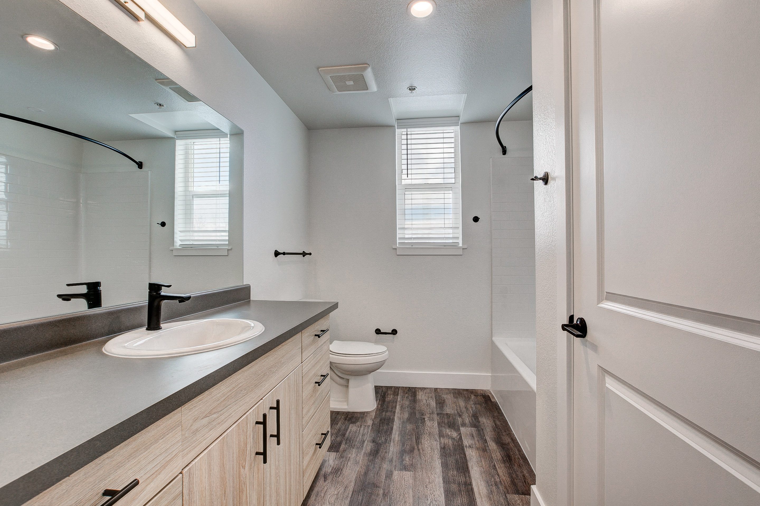 A bathroom with a sink, toilet, and a mirror.