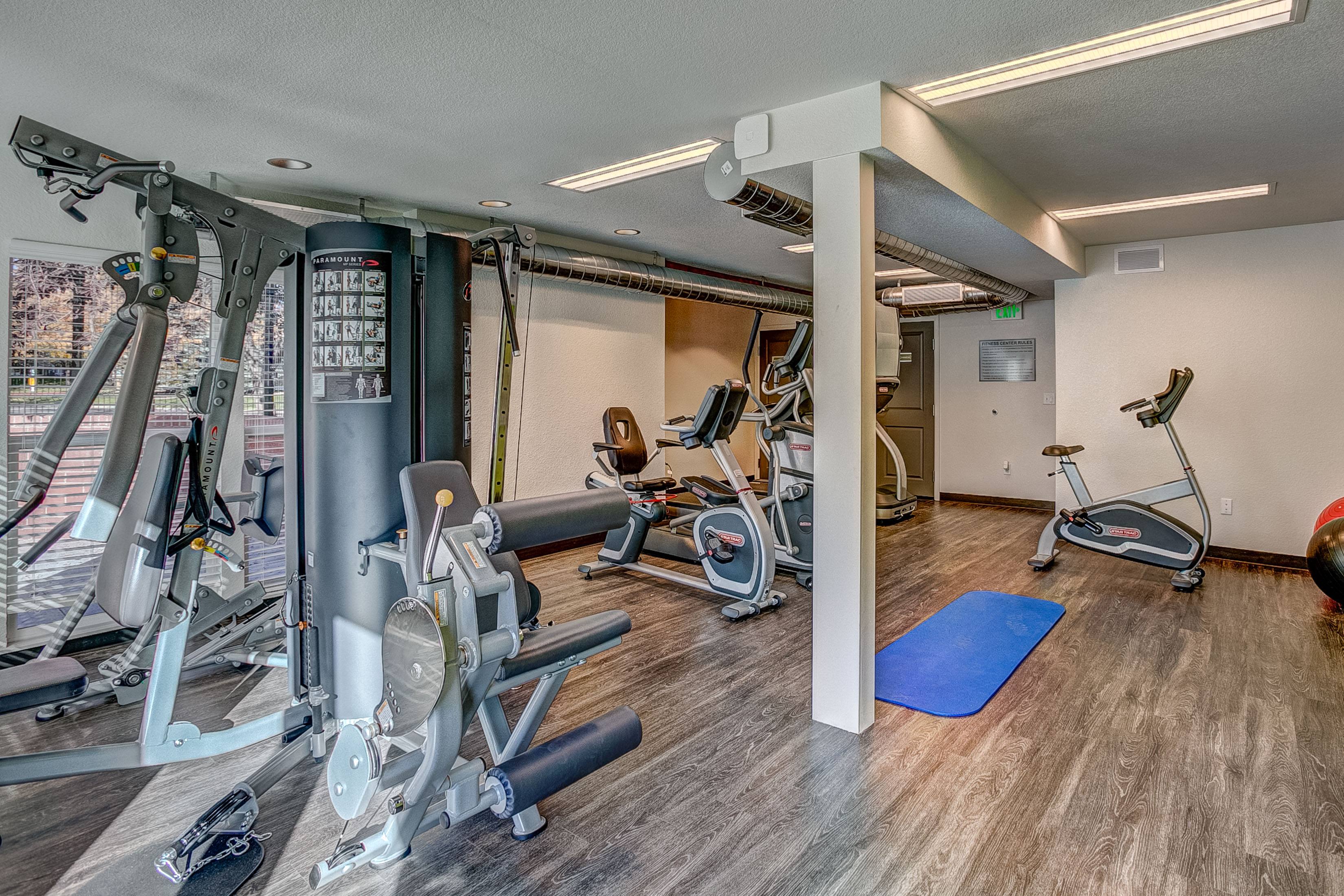 A woman is working out on a rowing machine in a gym.