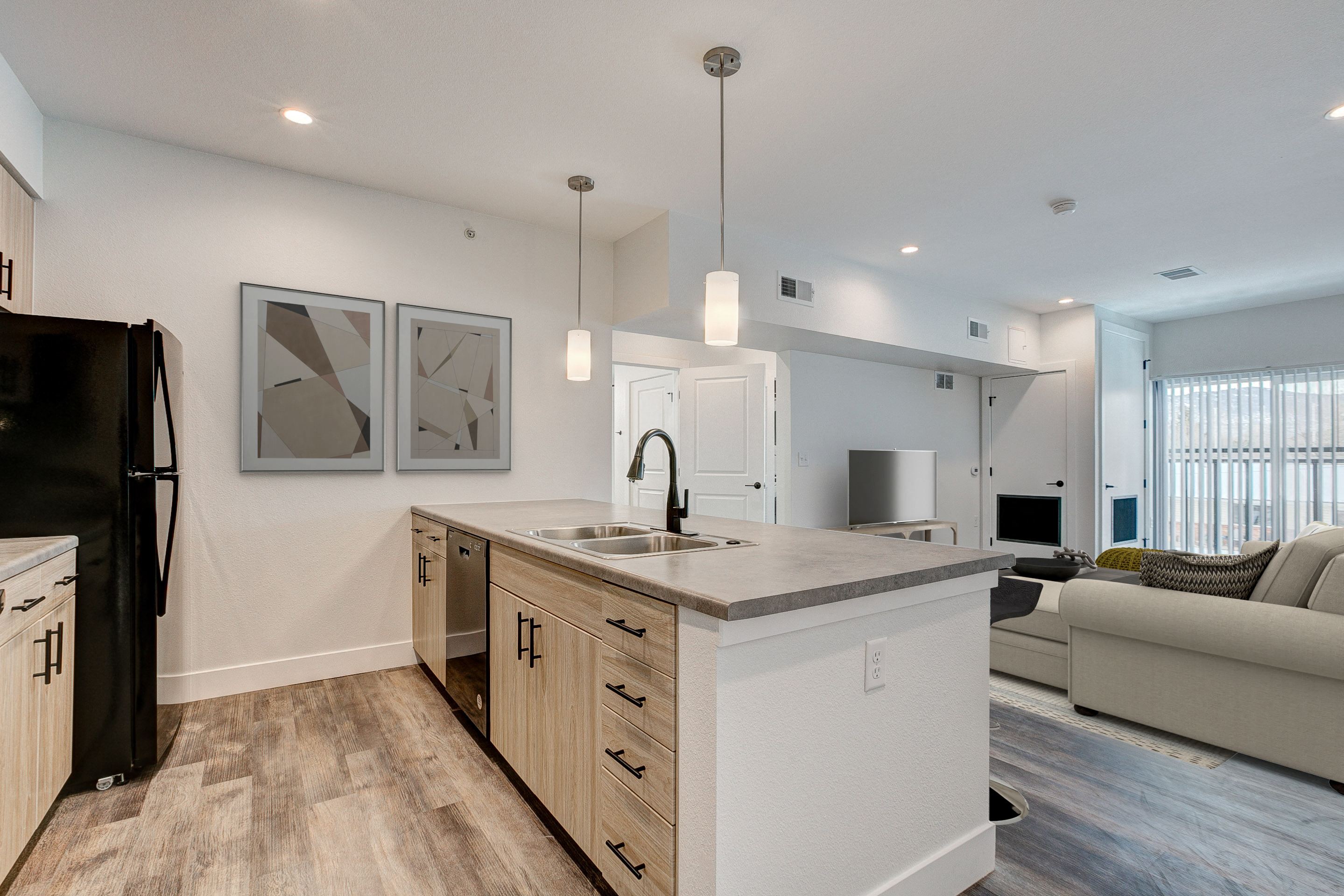 A modern kitchen with a black refrigerator and wooden cabinets.