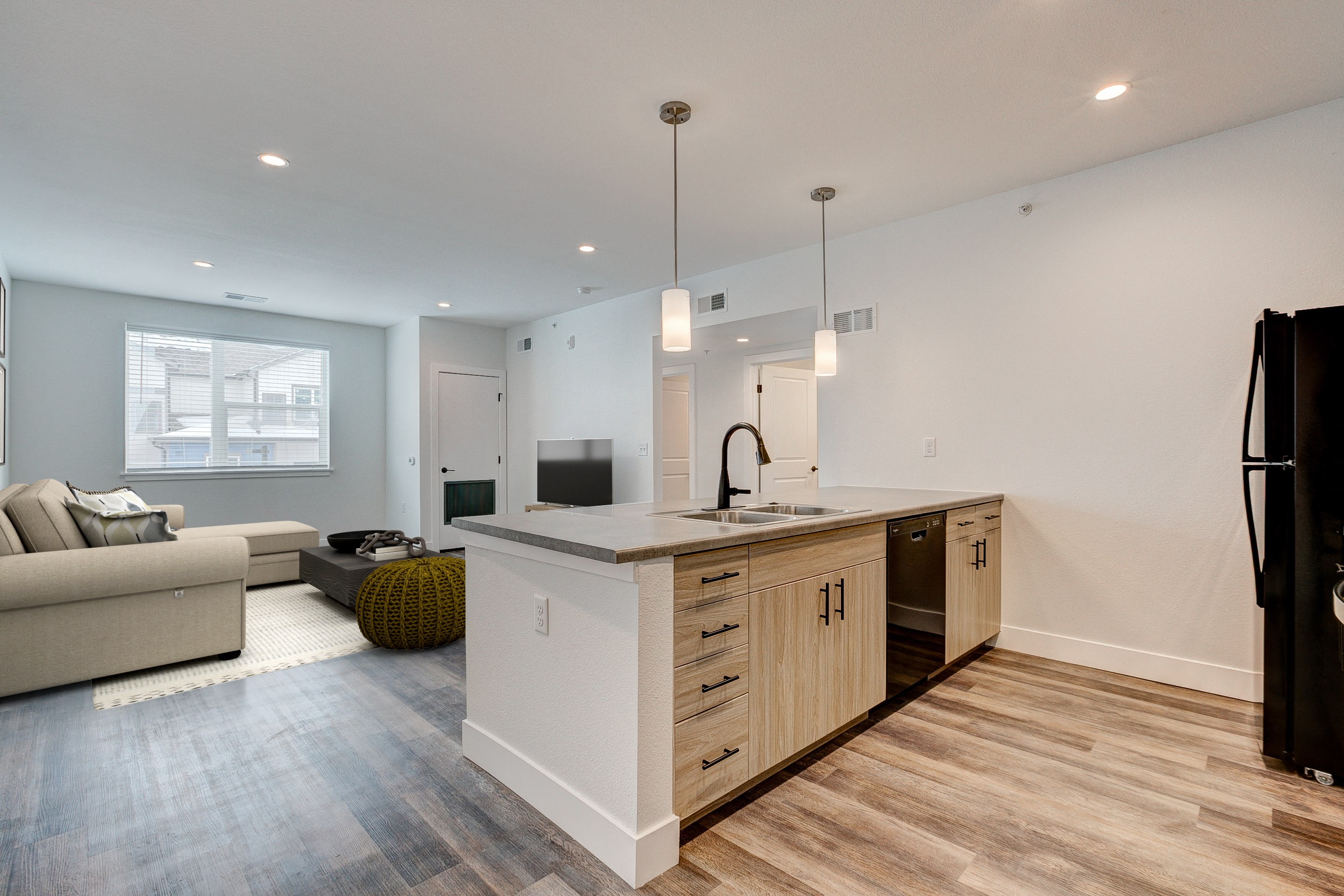 A modern kitchen with a white island and wooden floors.