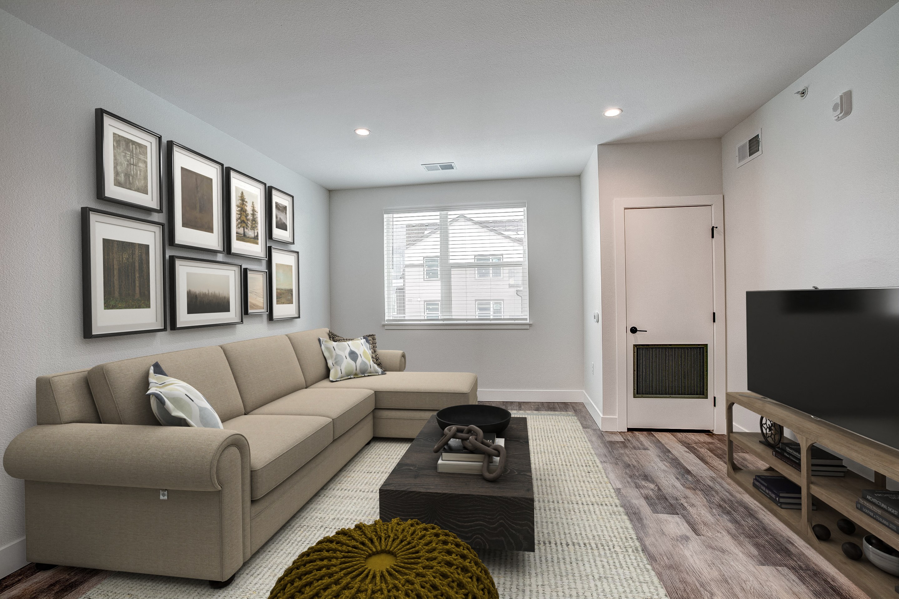 A living room with a couch, coffee table, and pictures on the wall.