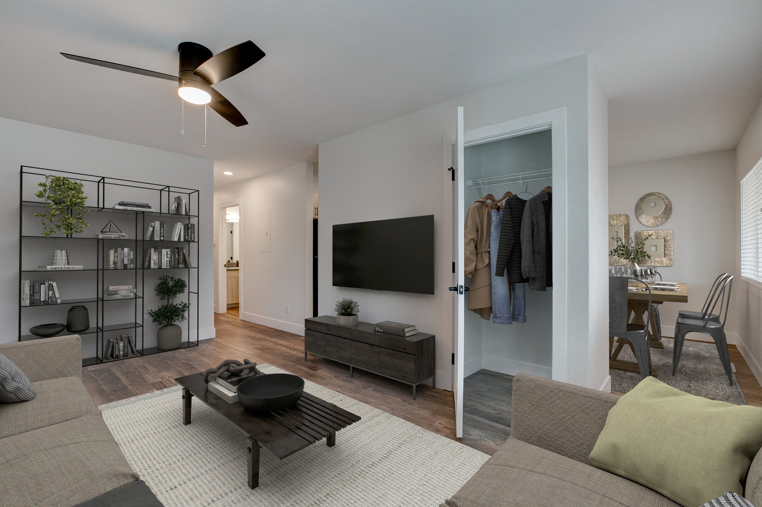 A living room with a ceiling fan and a flat screen TV.